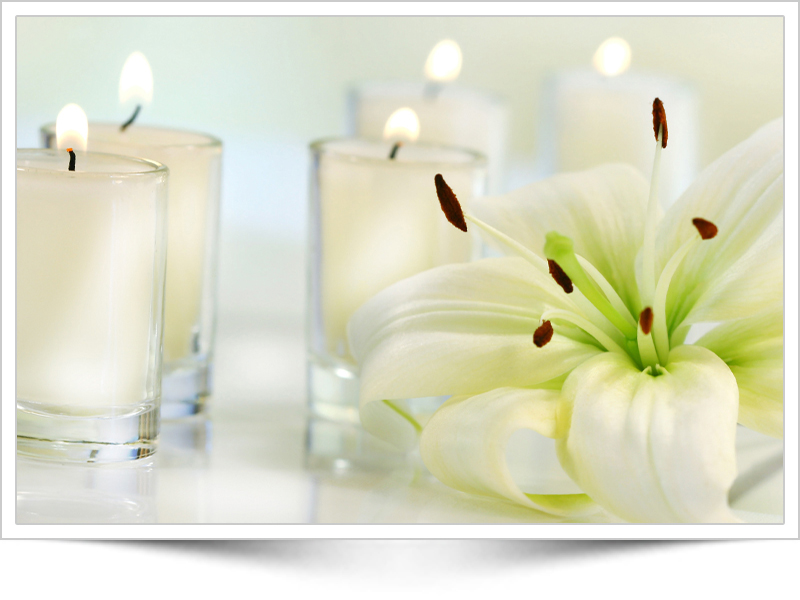 Orange lilly, pebbles and a candle